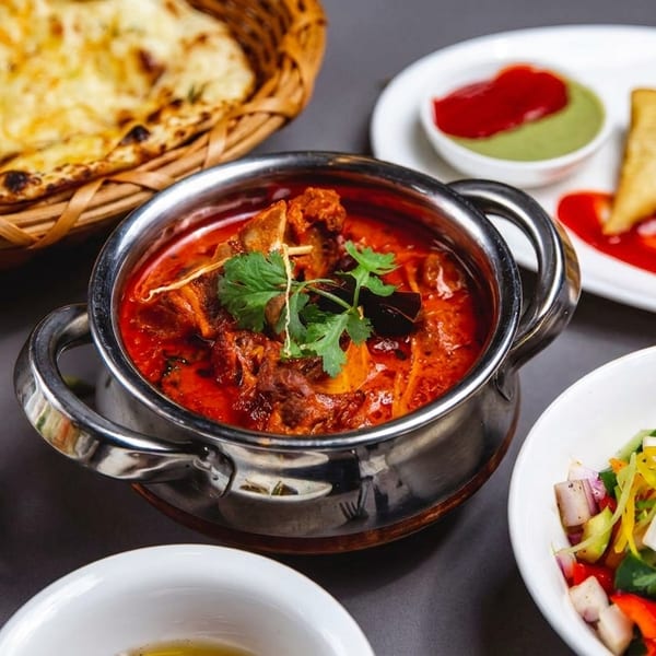 A vibrant Indian feast with naan, curry, samosas, fried rice, and a fresh salad.