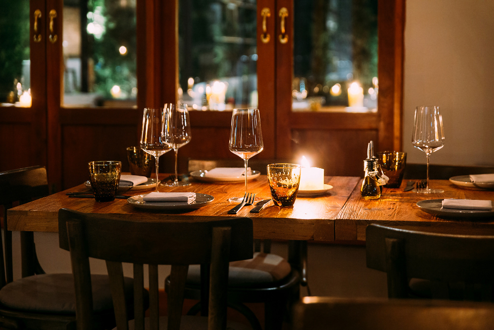 a table with wine glasses and candles on it Budget-friendly takeout dinner at affordable restaurant
